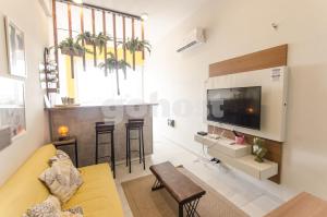sala de estar con sofá amarillo y mesa en Unbeatable Studio W Pool, Wifi In Villa Morra, en Asunción