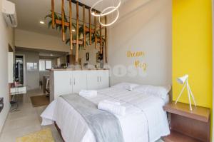 1 dormitorio con 1 cama grande y cocina en Unbeatable Studio W Pool, Wifi In Villa Morra, en Asunción