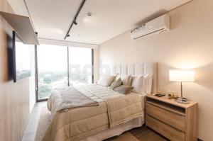 a bedroom with a large bed and a large window at Exclusive And Luxurious Penthouse In Herrera in Asuncion