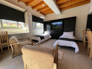 a bedroom with two beds and a couch and chairs at Ayres home in Mendoza