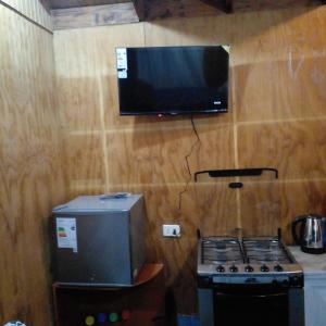 a kitchen with a stove and a tv on a wall at Alojamiento Pichidangui in Pichidangui