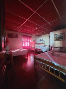 a large room with two beds and a room with a bed sqor at El Mirador in Juayúa