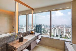 a bathroom with a large window overlooking a city at PARKROYAL Serviced Suites Jakarta in Jakarta +41 photos