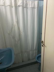 baño con cortina de ducha blanca y aseo azul en SANBERJERE en San Bernardo