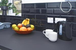 a bowl of fruit sitting on a counter with a coffee maker at The Green House in Stoke on Trent