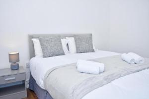a bedroom with a white bed with towels on it at The Green House in Stoke on Trent