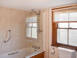 a bathroom with a shower and a tub and a toilet at Quince Cottage in Clifton