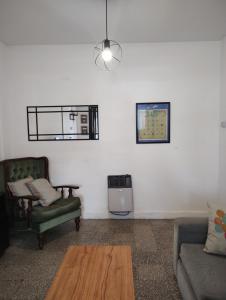 ein Wohnzimmer mit 2 Stühlen und einem Tisch in der Unterkunft Una casita en la loma in La Plata