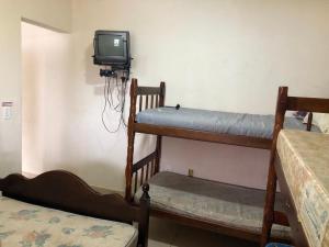 伊利亞孔普里達的住宿－Apartamentos Ilha Comprida，客房设有两张双层床和电视。