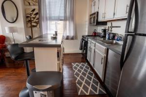 a kitchen with a stainless steel refrigerator and a counter at Cozy historic 3rdfl apartment in Baltimore