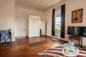 a living room with a table and a flat screen tv at Cozy historic 3rdfl apartment in Baltimore