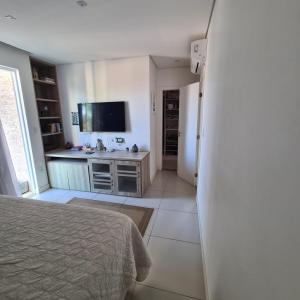 a bedroom with a bed and a kitchen with a sink at Casa com piscina a 800 metros da praia de Buraquinho in Lauro de Freitas