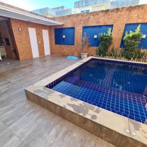 Casa com piscina a 800 metros da praia de Buraquinho في لورو دي فريتاس: مسبح وبلاط ازرق على مبنى