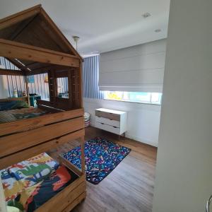 Casa com piscina a 800 metros da praia de Buraquinho في لورو دي فريتاس: غرفة نوم بسرير مع اطار خشبي