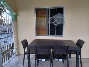 a table and chairs in front of a window at Paradise suite in Old Harbour in Old Harbour