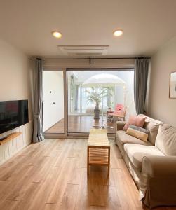 a living room with a couch and a table at La Pause Pension in Seogwipo