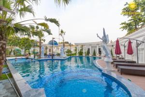 een zwembad in een resort met palmbomen bij Minh Đức Hotel 