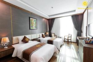 een hotelkamer met 2 bedden en een televisie bij Minh Đức Hotel 