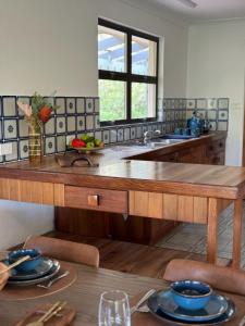 a kitchen with a large wooden table with a sink at Amongst the Trees in Mooloolah