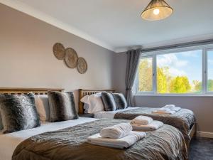 two beds in a room with a window at Bridge Farm in Uttoxeter