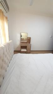 a bedroom with a white bed and a chair at Anc mall area east legon guest house in Accra