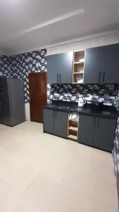 a kitchen with black and white tiles on the wall at Anc mall area east legon guest house in Accra