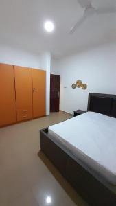 a bedroom with a bed and wooden cabinets at Anc mall area east legon guest house in Accra