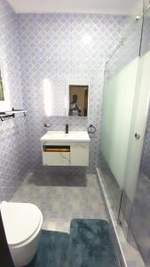 a bathroom with a toilet and a sink and a mirror at Anc mall area east legon guest house in Accra