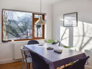 een eetkamer met een tafel en stoelen en een raam bij The Croft in Threlkeld