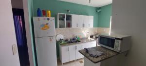 eine Küche mit einem weißen Kühlschrank und einer Mikrowelle in der Unterkunft CASA CON PILETA Y COCHERa in La Rioja