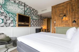 een slaapkamer met een bed en een tv aan de muur bij Leonardo Hotel Vinkeveen Amsterdam in Vinkeveen