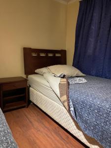 a small bedroom with a bed and a night stand at Alojamientos OPV in Calama