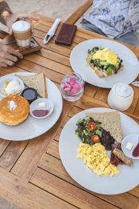 een tafel met borden ontbijtproducten erop bij Ama-Lurra Resort in Gili Air