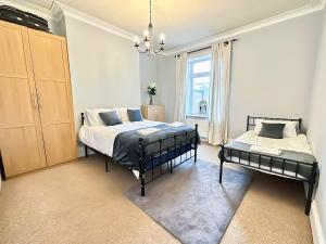 a bedroom with two beds and a window at Victoria House By The Sea in Whitley Bay