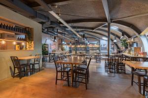 a restaurant with tables and chairs and a bar at Leonardo Hotel Almere City Center in Almere