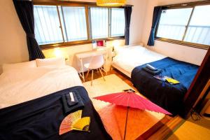 a bedroom with two beds and a red umbrella at 地下鉄花園町駅徒歩2分 なんば駅まで電車で2分 2階建て戸建て貸切 キッチン充実 長期滞在可 in Osaka