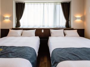 2 camas en una habitación con ventana en Private Condo Chatan Jagaru by Coldio Premium, en Chatan