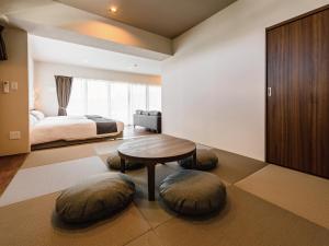 Schlafzimmer mit einem Bett, einem Tisch und Stühlen in der Unterkunft Private Condo Chatan Jagaru by Coldio Premium in Chatan