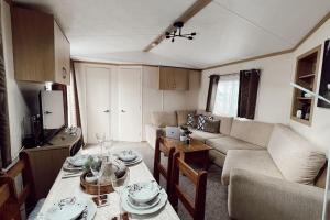 a living room with a couch and a table at Melrose in Leysdown-on-Sea
