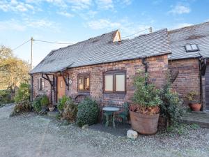 a brick house with a table in front of it at Rickyard Cottage- Uk45535 in Buildwas