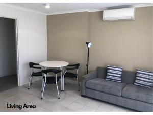 uma sala de estar com um sofá e uma mesa em BASE Holidays - Ettalong Beach Premium Apartments em Ettalong Beach