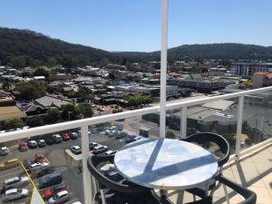 uma mesa numa varanda com vista para um parque de estacionamento em BASE Holidays - Ettalong Beach Premium Apartments em Ettalong Beach