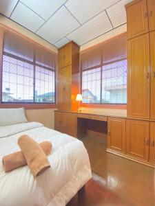 a bedroom with a bed with a desk and windows at Ipoh Center Elegant Bungalow Near to Sunway in Ipoh