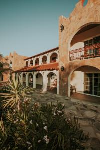 an outside view of a building with a patio at Hacienda Los Olivos, Valle de Guadalupe in Rancho Grande