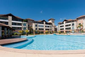 una gran piscina frente a algunos edificios de apartamentos en Cobertura Duplex Jacuzzi - Mediterranee Residence, en Aquiraz