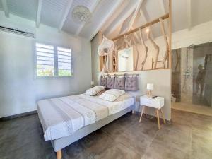 a bedroom with a large bed in a room at cannelle in Sainte-Anne +5 photos