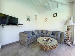 a living room with a couch and a table at cannelle in Sainte-Anne
