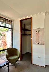 een woonkamer met een stoel en een raam bij Tranquil home in hills with city views 