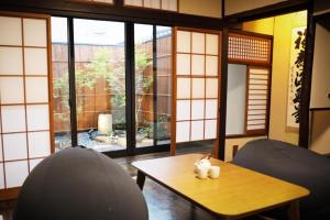 Zimmer mit einem Tisch, Stühlen und Fenstern in der Unterkunft 一吾山房 in Kyoto