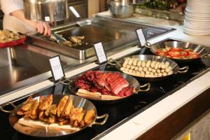 a kitchen with several pans of food on a stove at Hilton Wenchang in Wenchang